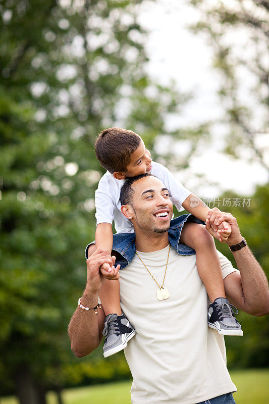 Happy Dad Carrying Son on His Shoulders Outside .快乐爸爸在外面扛儿子